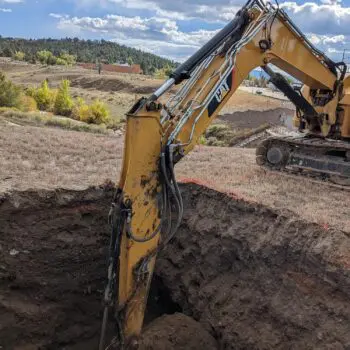 Excavator digging trench construction site