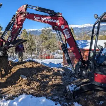 Excavator digging in snowy ground