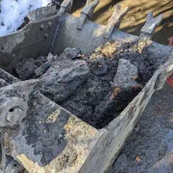 Excavator digging muddy soil construction