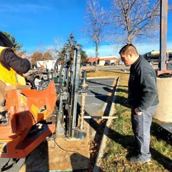 Construction workers operating drilling equipment