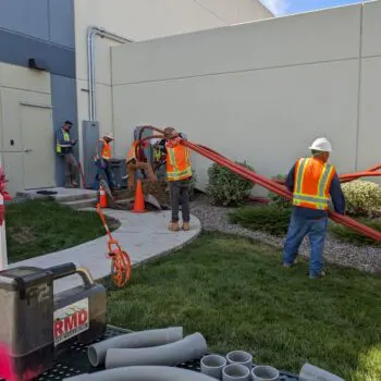 Construction workers installing utility conduits