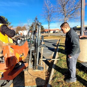 Construction workers operating drilling equipment