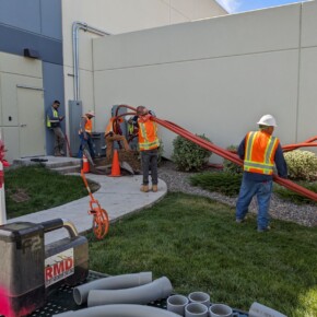 Construction workers installing utility conduits