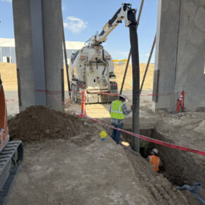 Construction workers operating vacuum truck